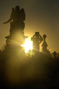 light between cemetery sculptures, black and yellow tonality