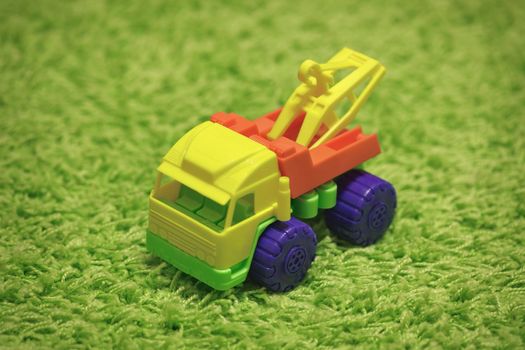 Small plastic toy - a car on green carpet