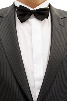 Breast solemnly dressed young man in a tuxedo with bow tie