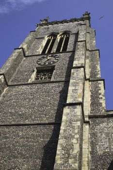 old church tower taken from directly below with the blue sky above