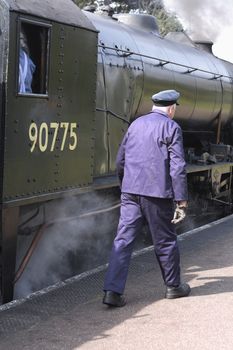 steam engine driver checking his train out