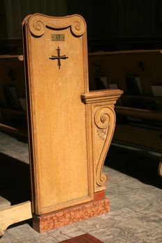 A pew cast in bright sunlight, in a beautiful cathedral.