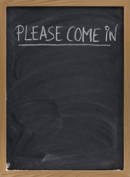 please come in invitation handwritten with white chalk on a small blackboard with eraser smudges, copy space below