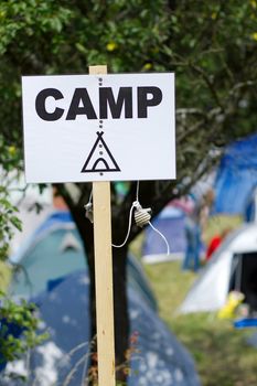 Camp sign with tents in the background