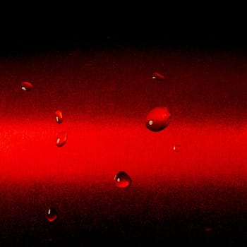 Some raindrops on red metallic surface