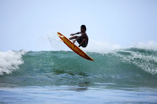 Surfer in ocean on sunset. Bali. Indonesia