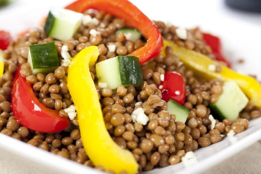 Fresh and healthy vegetarian lentil salad with red and yellow peppers.