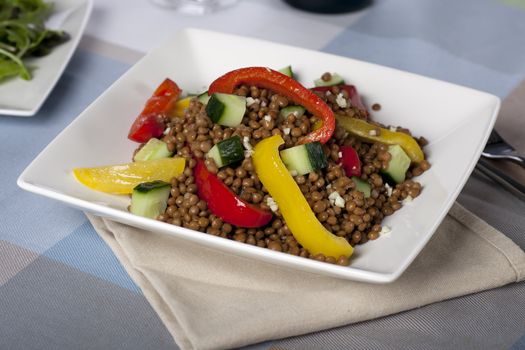 Fresh and healthy vegetarian lentil salad with red and yellow peppers.