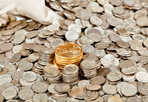 Linen bag of old pure silver coins used to invest in silver as a commodity with a selection of Golden Eagle gold coins