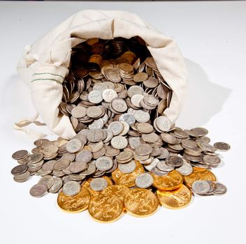 Linen bag of old pure silver coins used to invest in silver as a commodity with a selection of Golden Eagle gold coins