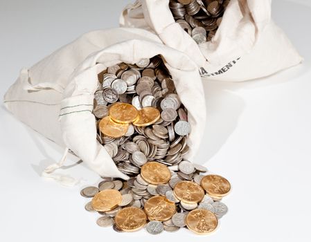 Linen bag of old pure silver coins used to invest in silver as a commodity with a selection of Golden Eagle gold coins