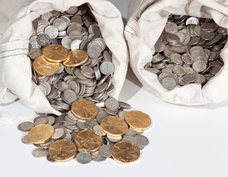 Linen bag of old pure silver coins used to invest in silver as a commodity with a selection of Golden Eagle gold coins