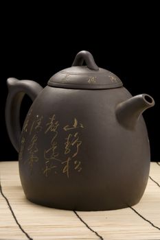 teapot on mat with clipping path over black background