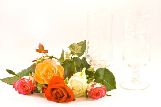 Five roses and two by hand engraved glasses on white background