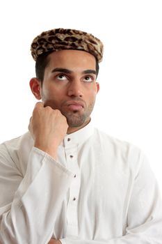 An ethnic man wering a white embroidered robe fastened with claw set rubies and wearing vintage leopard skin hat.  He is looking up and thinking or pondering.   Space for copy.   White background.