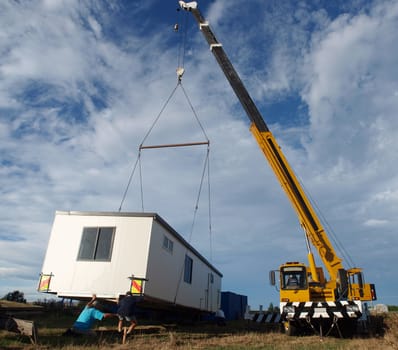 Large Crane lifting a temporary housing unit into place     