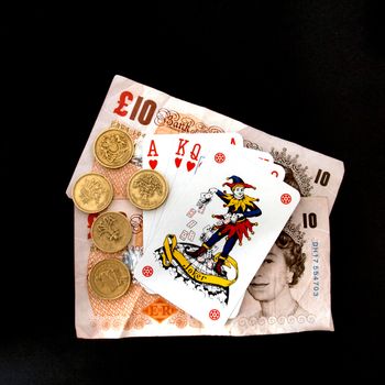 Concept of gambling showing coins, the joker  playing cards.