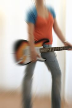 female guitarist playing electric guitar with radial blurr