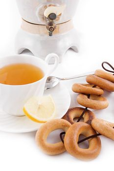Samovar and tea cup with bagels over white