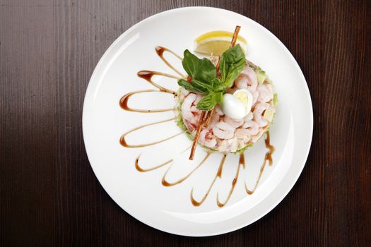 plate with shrimp salad on brown table with clipping path