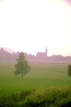 Church seen through summer morning mist