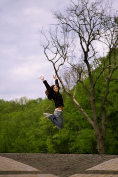 young girl jumping over alley in park