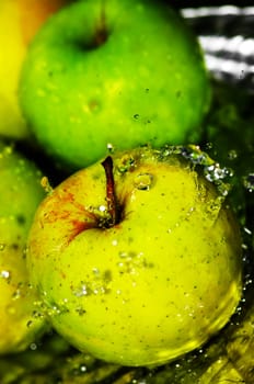 fresh water splash on green apple on metal background