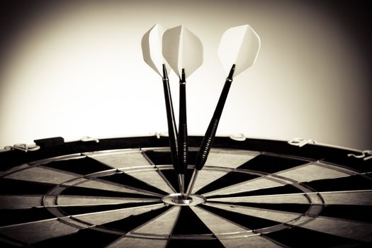 Perspective Photo Of Three Arrows Hitting The Center Of Darts Table