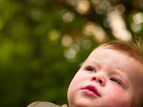 Sweet baby boy looking up at copy space