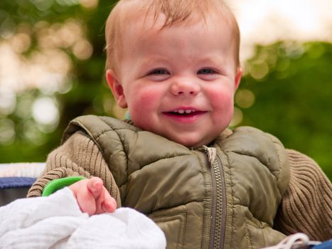 Happy baby boy laughing with joy and pointing