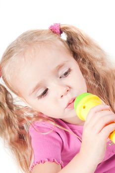 Little cute girl in pink and with ponytails in studio