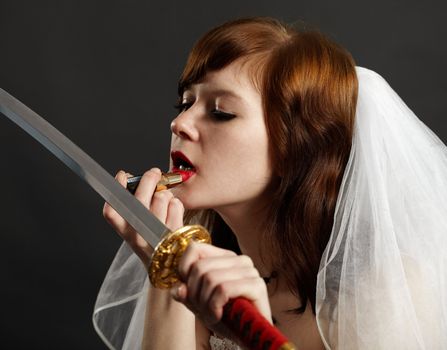 Bride lipstick using the reflection in the sword on dark background