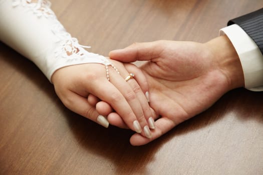 Hands of a newly-married couple close up