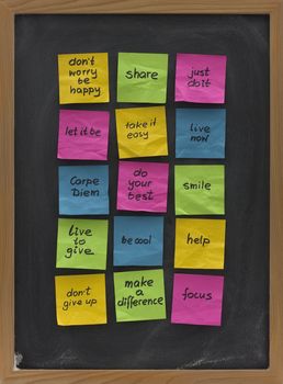 colorful crumpled sticky notes with uplifting and motivational words of wisdom posted on blackboard