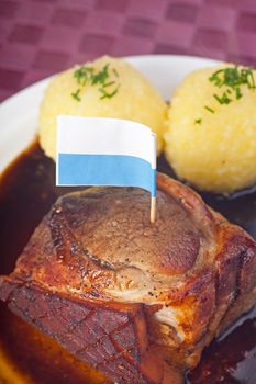 traditional bavarian roast pork with beer sauce and dumplings