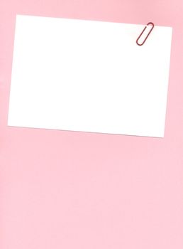 paperclip on a postit note over a pink background
