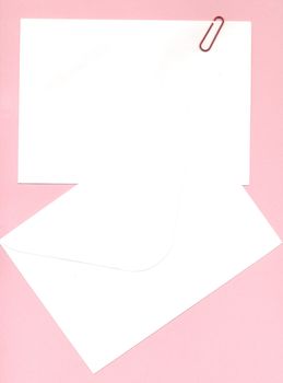 memo notepaper and envelope over pink