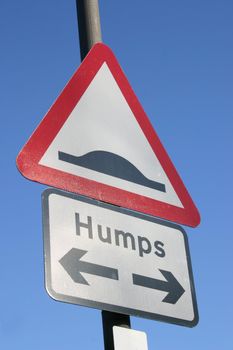 sign depicting humps in the road in both directions