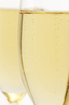 glass with champagne closeup in front of other on white background