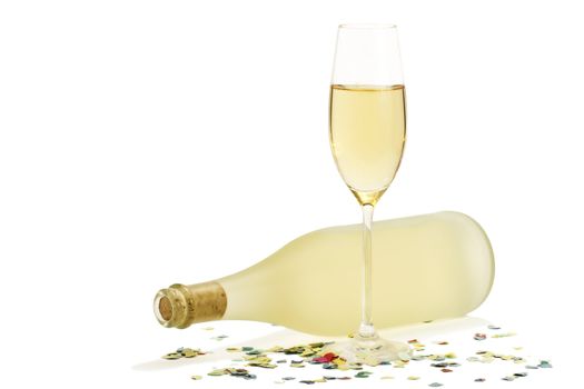glass of champagne in front of dull prosecco bottle with confetti on white background