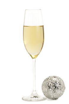 glass of champagne with a metal christmas ball on white background