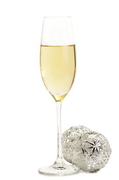 glass of champagne with two metal christmas balls on white background