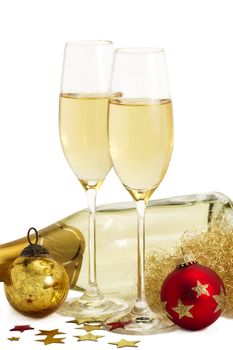 two glasses of champagne with angels hair, metal stars, red and golden christmas balls in front of a champagne bottle on white background