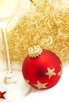 red christmas ball from top with angels hair and a champagne glass on white background