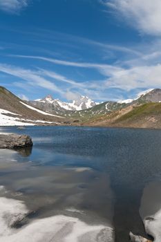 small lake in  Pointe Rousse pass, Aosta valley, Italy with Mont Blanc massif on background