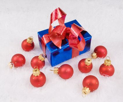 Red spheres and blue box with red bow on the white 