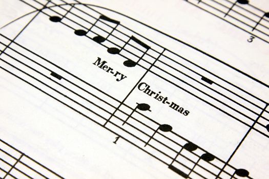 Merry Christmas text on a sheet of music.
