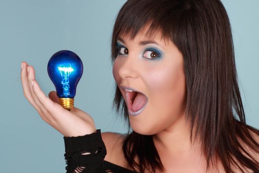 young woman holding a blue lightbulb