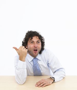 Happy businessman sitting at his desk isolated on white background