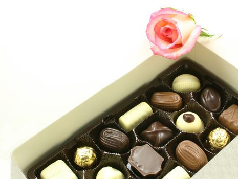 chocolates in a box with a rose on top